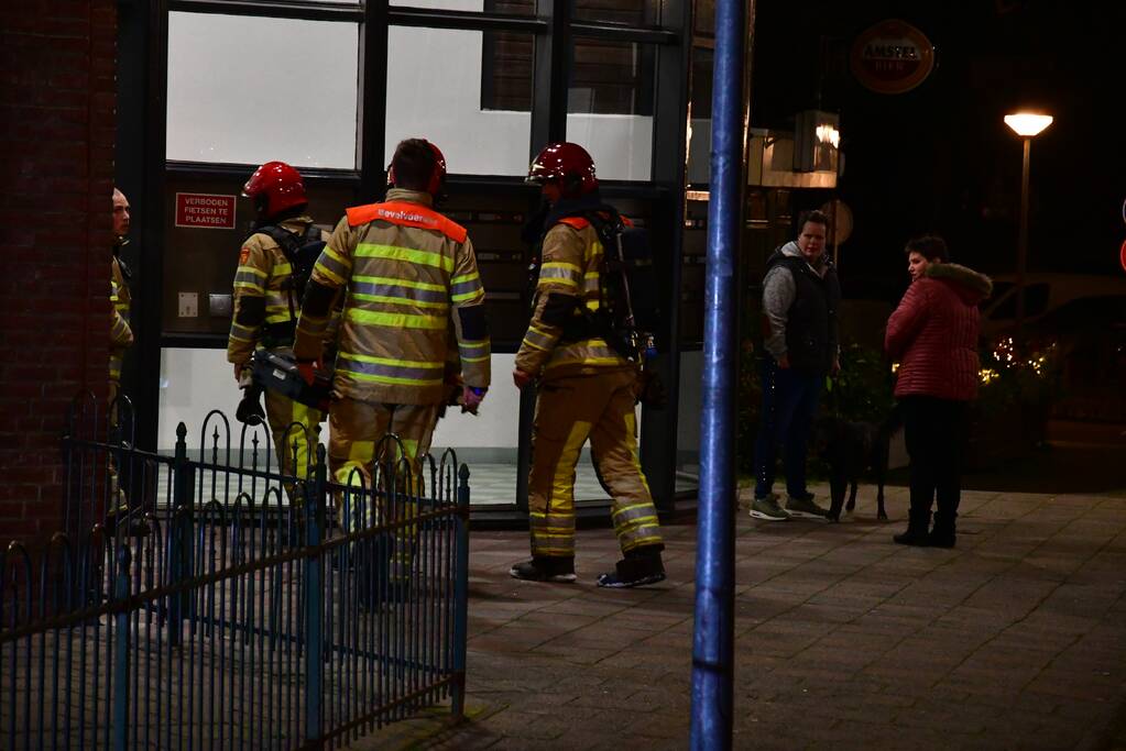 Brandweer blust brand onder balkon