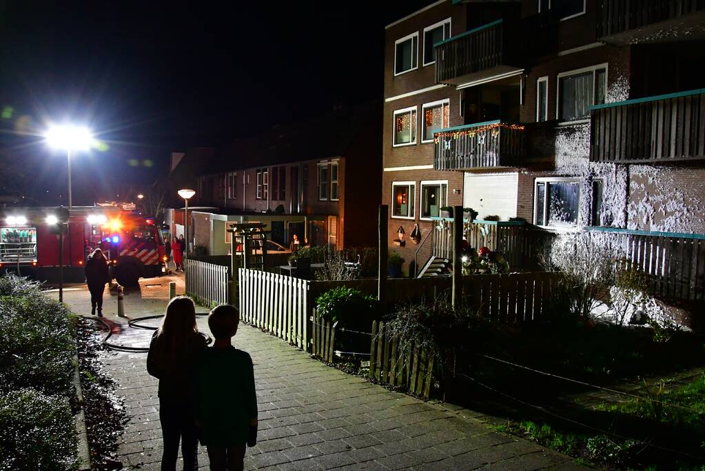 Brandweer blust brand onder balkon