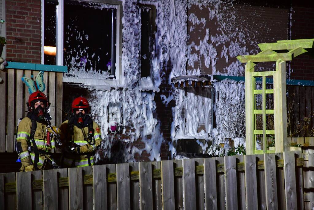 Brandweer blust brand onder balkon