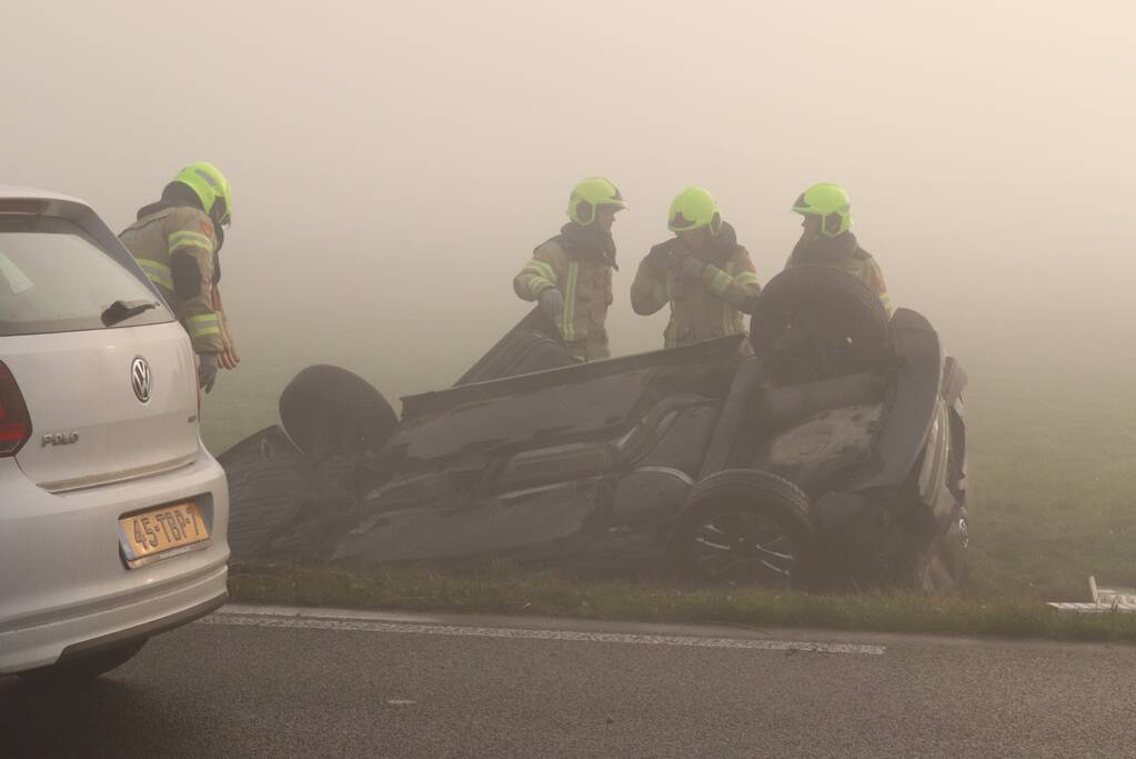 Auto op kop in sloot na botsing met andere auto