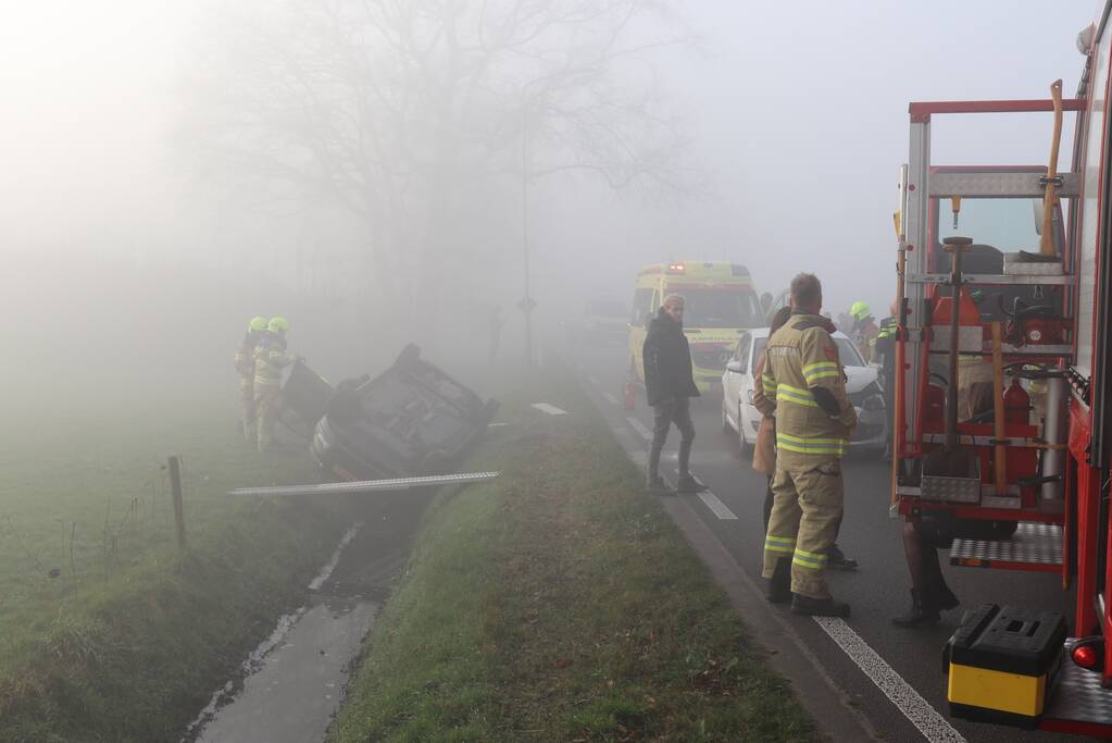 Auto op kop in sloot na botsing met andere auto
