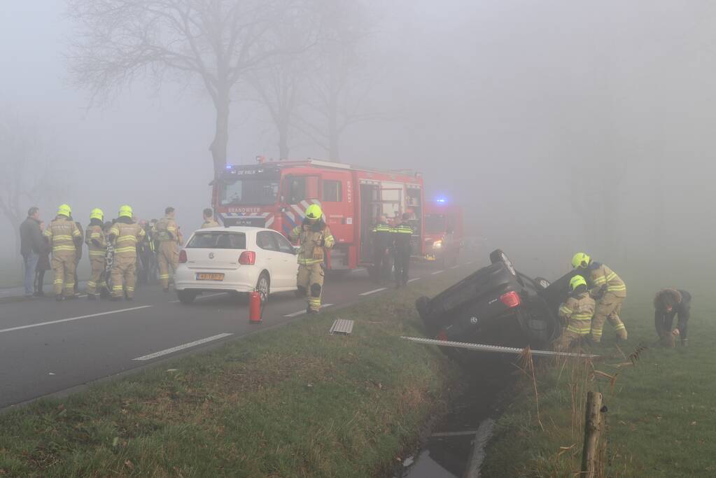 Auto op kop in sloot na botsing met andere auto
