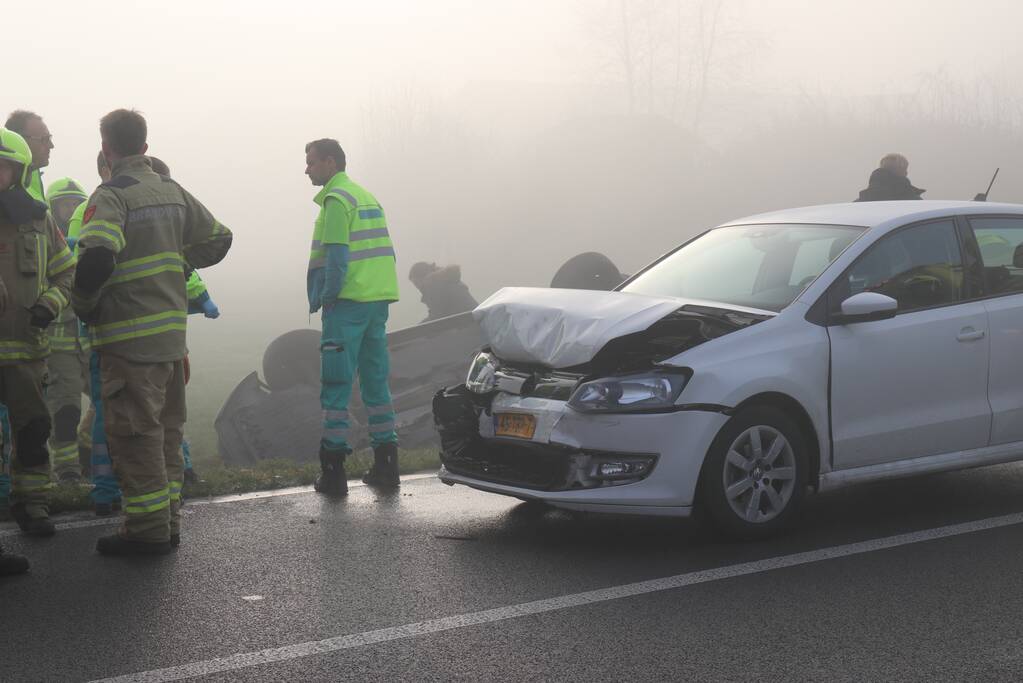 Auto op kop in sloot na botsing met andere auto