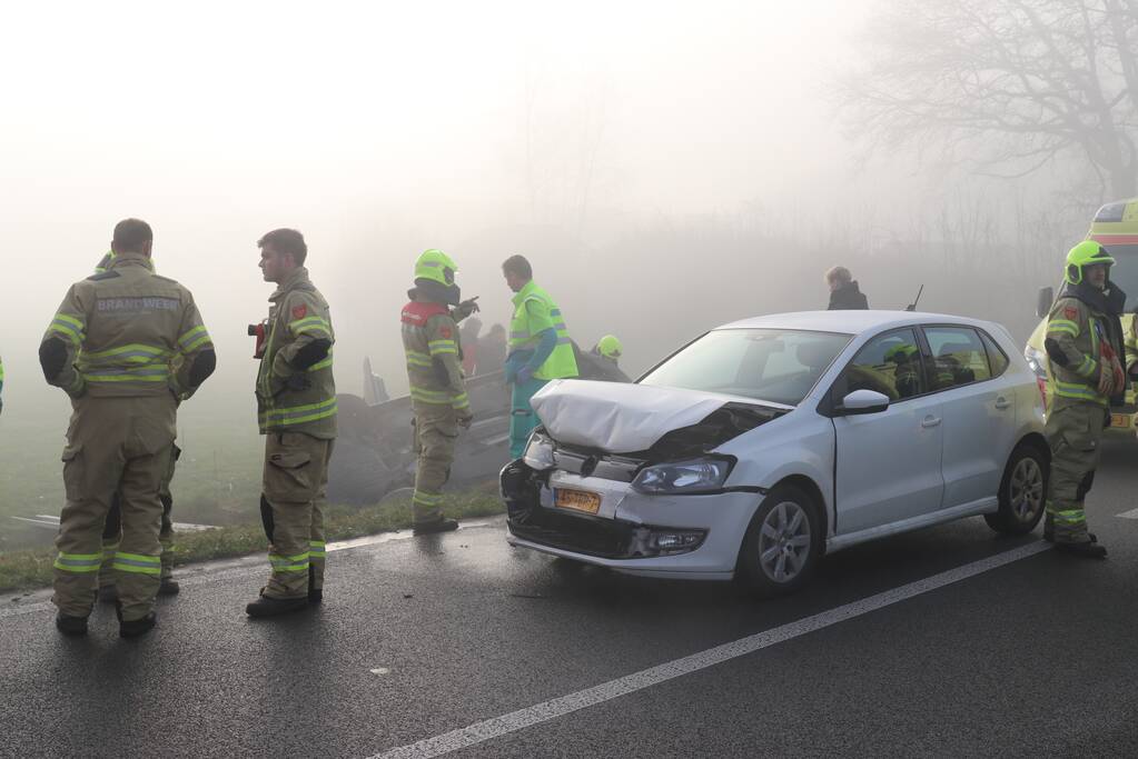 Auto op kop in sloot na botsing met andere auto