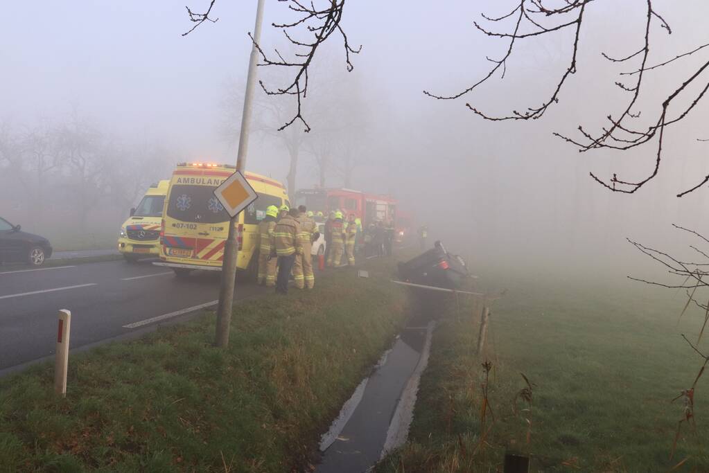 Auto op kop in sloot na botsing met andere auto