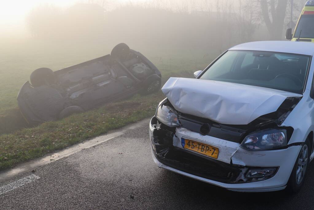 Auto op kop in sloot na botsing met andere auto