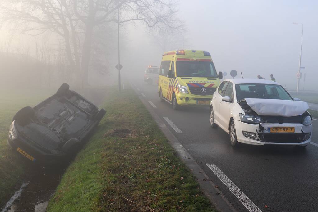 Auto op kop in sloot na botsing met andere auto