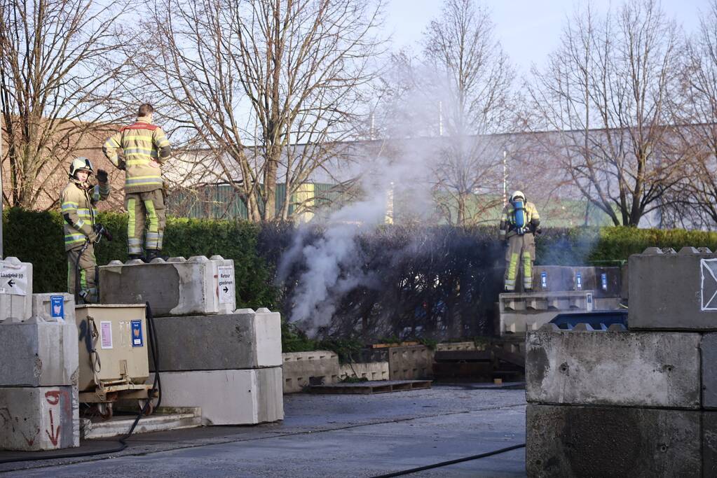 Dikke rookwolken door brand in coniferenhaag