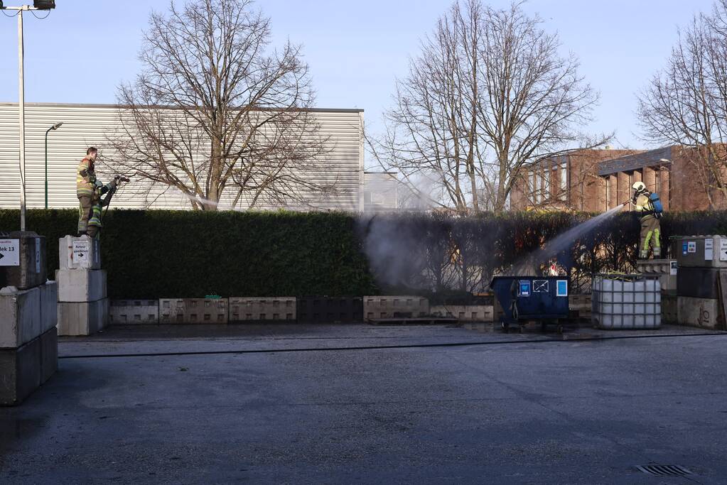 Dikke rookwolken door brand in coniferenhaag