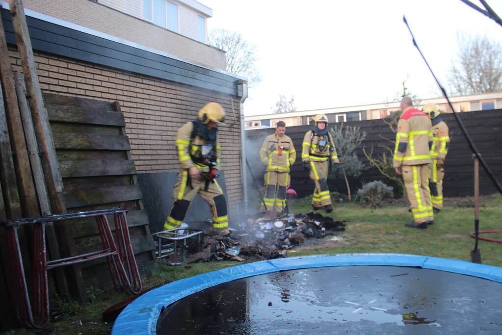 Brandweer blust afvalcontainer in tuin