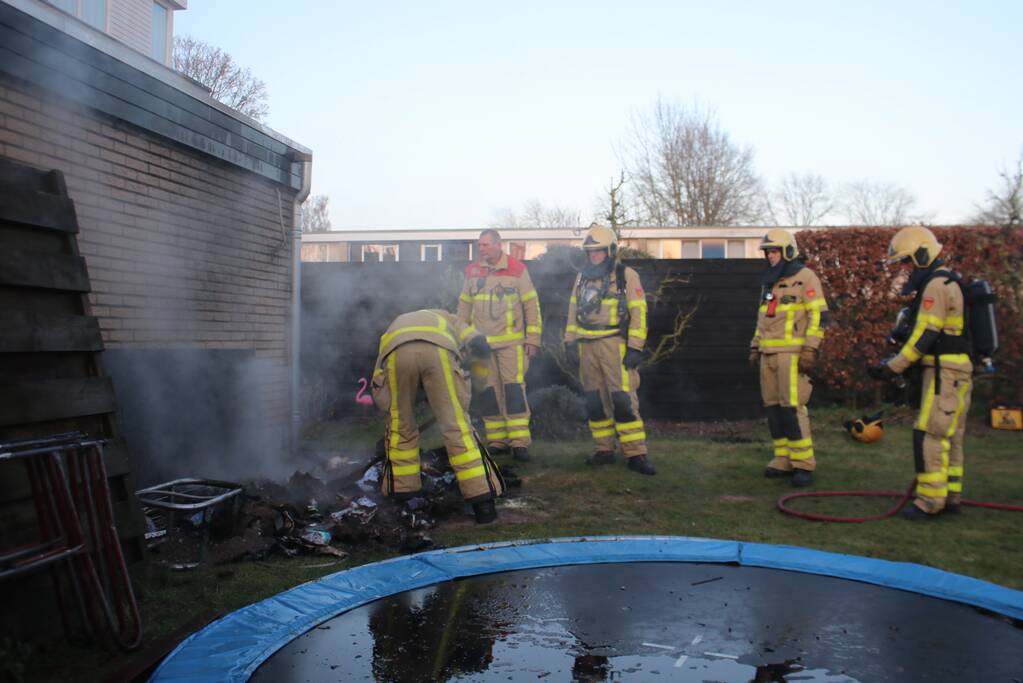 Brandweer blust afvalcontainer in tuin