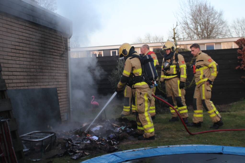 Brandweer blust afvalcontainer in tuin