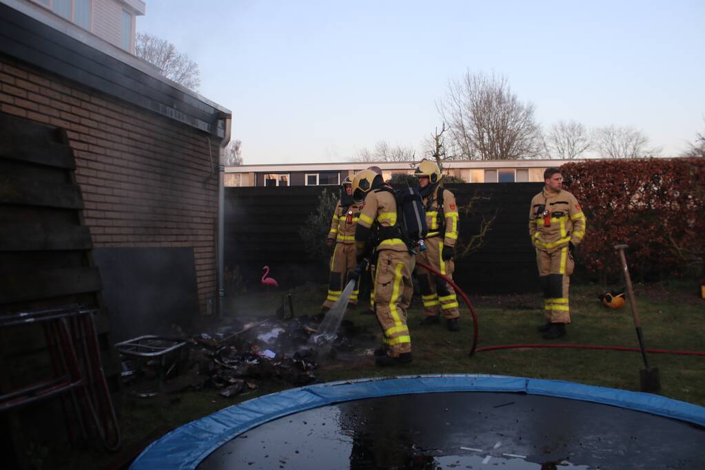 Brandweer blust afvalcontainer in tuin