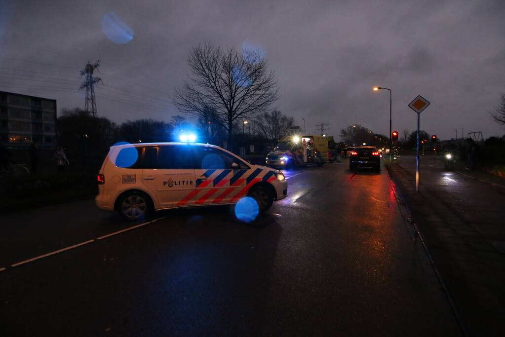 Personenauto schept wielrenner