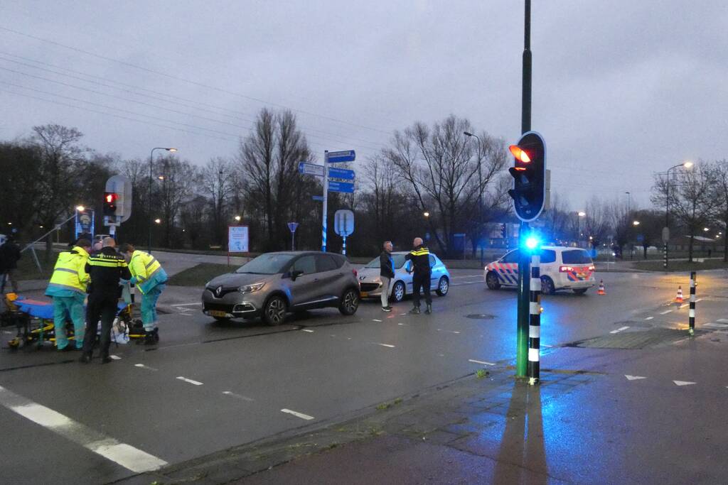 Personenauto schept wielrenner
