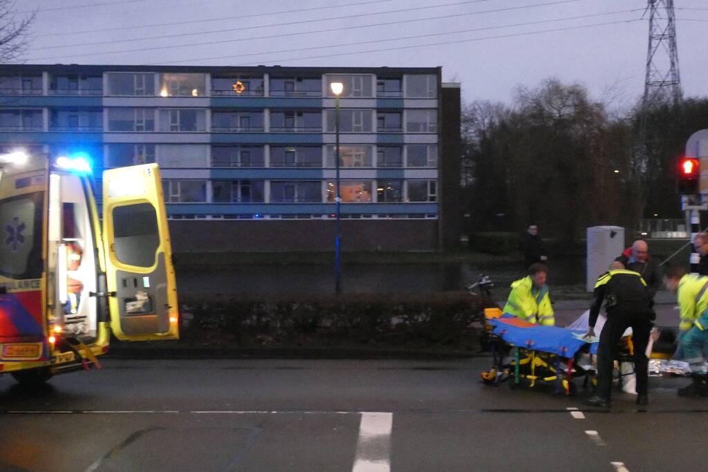 Personenauto schept wielrenner