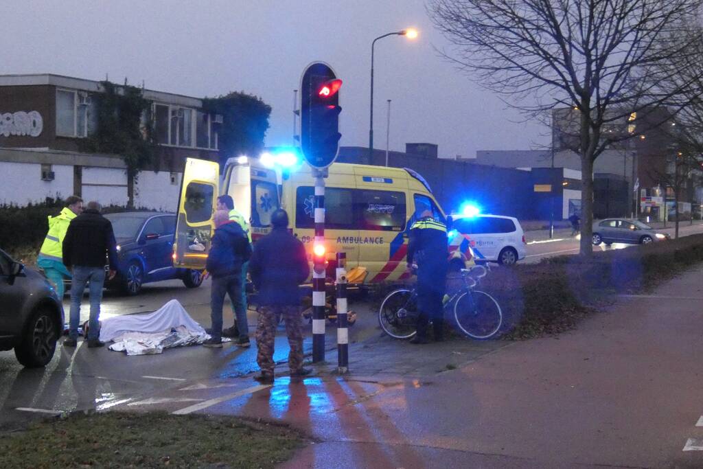 Personenauto schept wielrenner