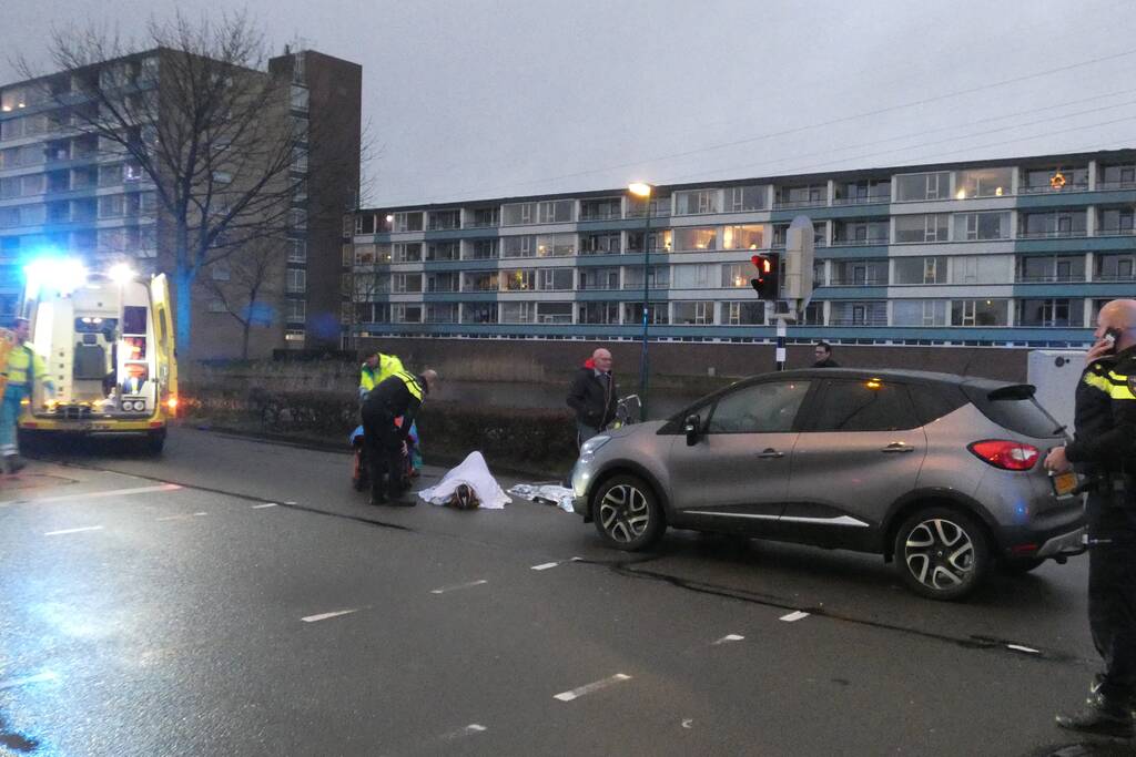 Personenauto schept wielrenner