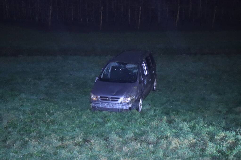 Auto vliegt uit de bocht op afrit en belandt in weiland