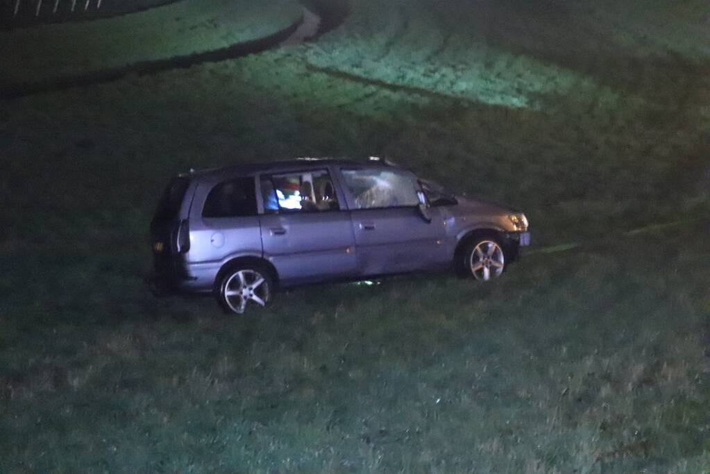Auto vliegt uit de bocht op afrit en belandt in weiland