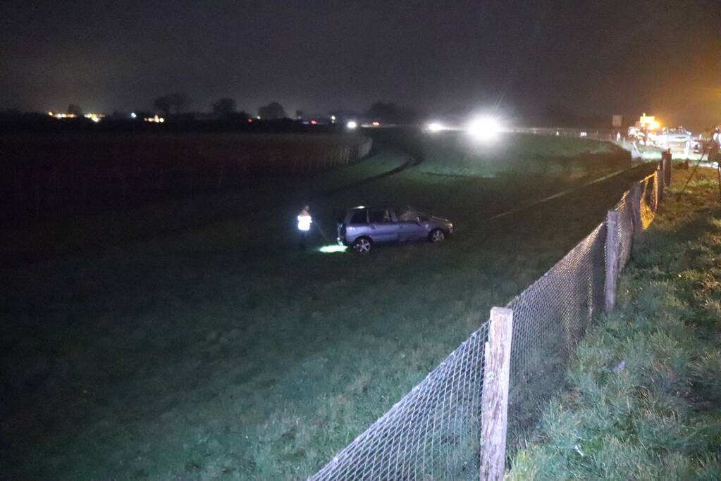 Auto vliegt uit de bocht op afrit en belandt in weiland