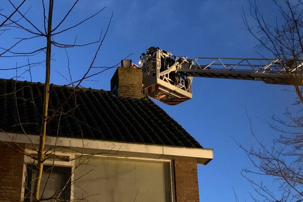 Brandweer controleert schoorsteenbrand met hoogwerker