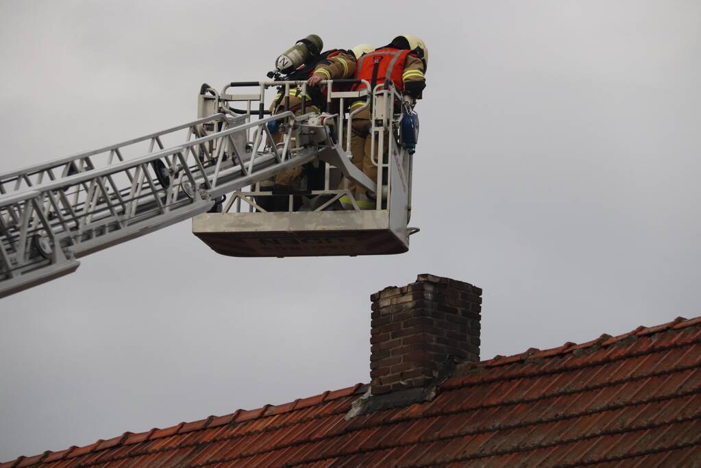 Brandweer veegt schoorsteen na brand