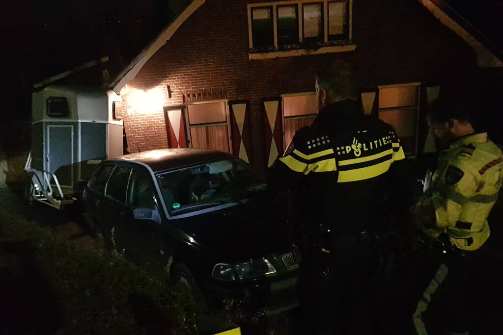 Auto met paardentrailer botst tegen huis.