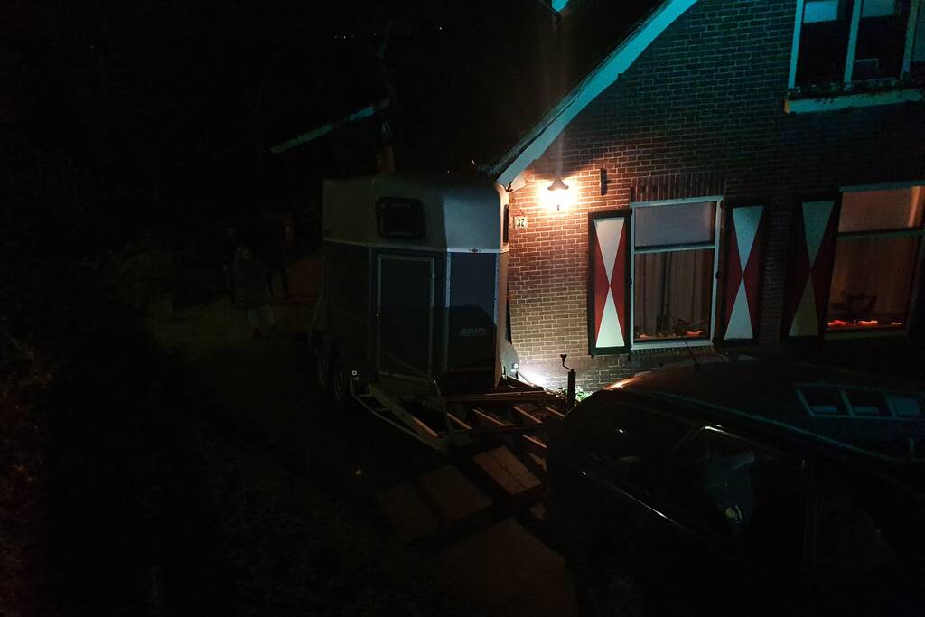 Auto met paardentrailer botst tegen huis.