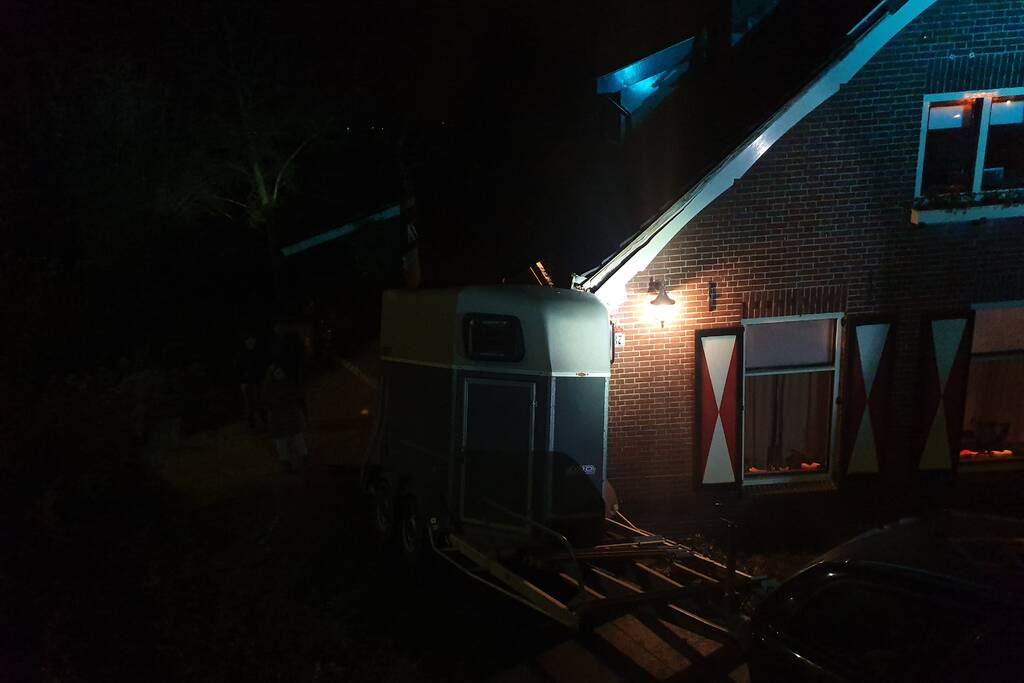 Auto met paardentrailer botst tegen huis.
