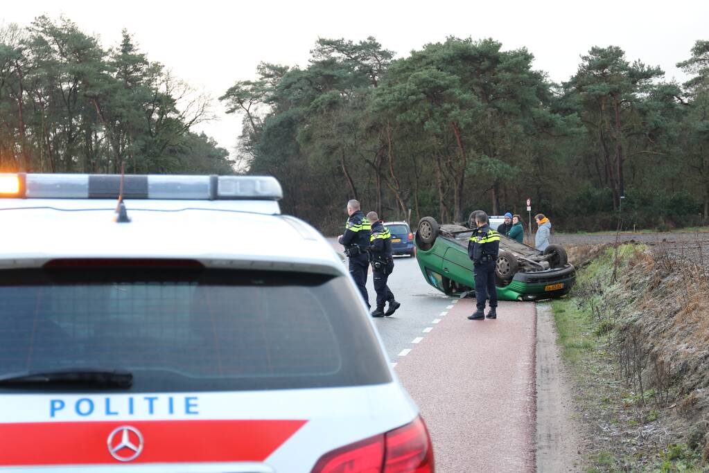 Auto vliegt over de kop op spekgladde weg