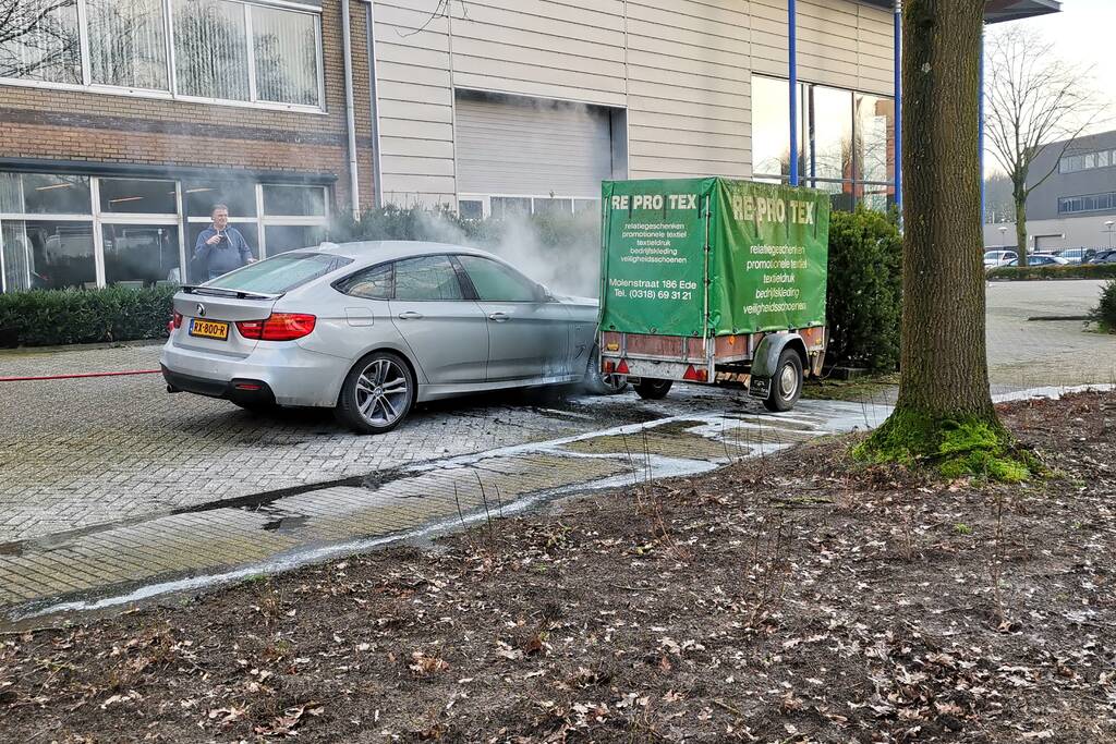 Medewerkers blussen beginnende autobrand