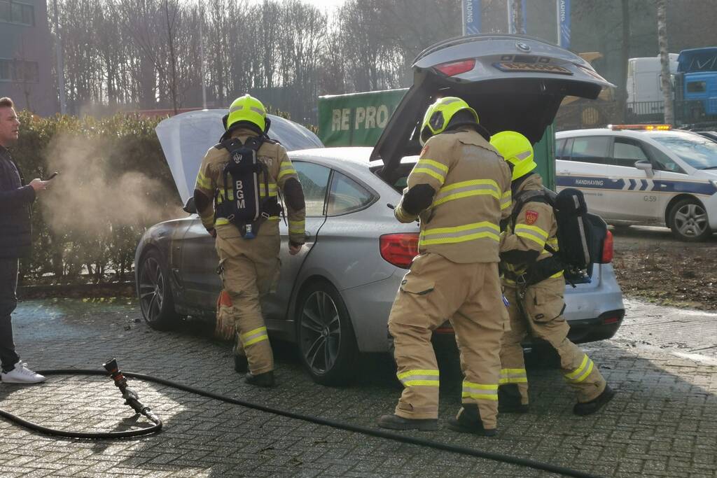 Medewerkers blussen beginnende autobrand