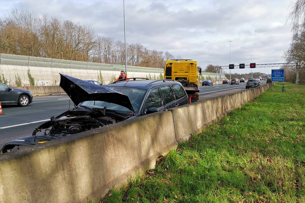 Auto boort zich in vangrail