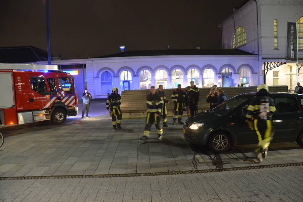 Brandweer inspecteert auto na brand