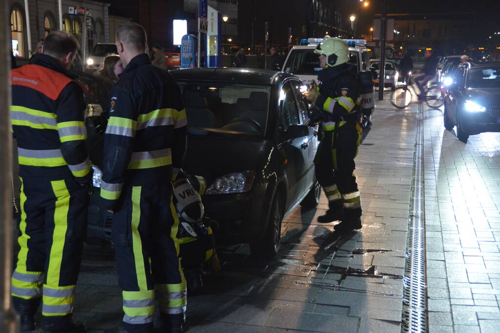 Brandweer inspecteert auto na brand