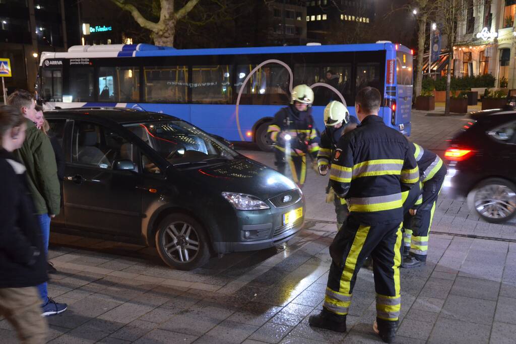 Brandweer inspecteert auto na brand