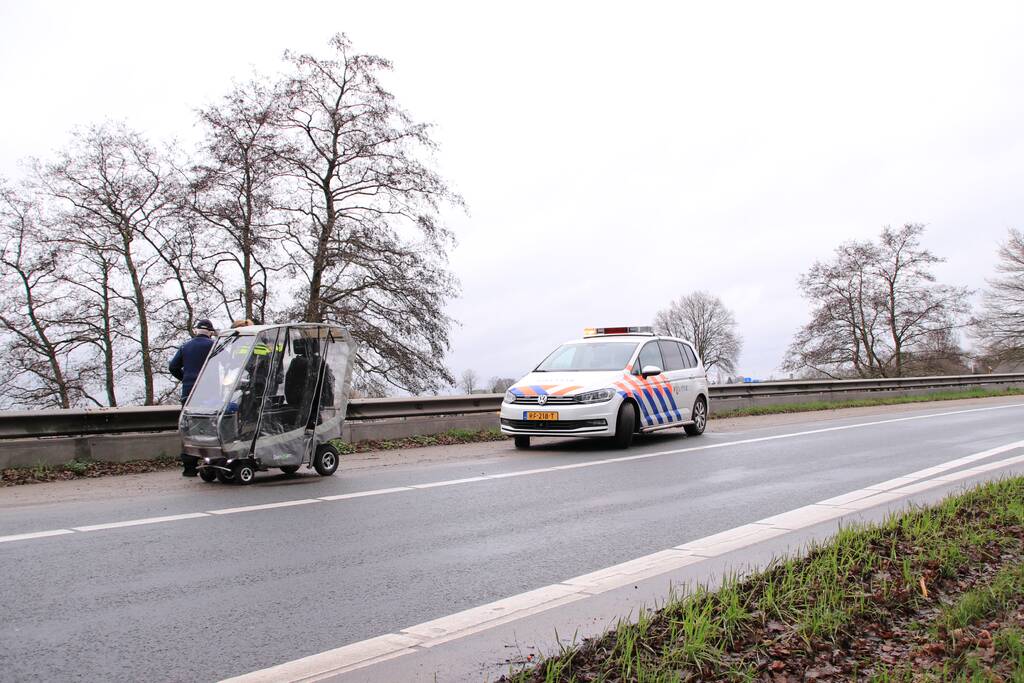 Bejaarde met brommobiel van oprit snelweg gehaald