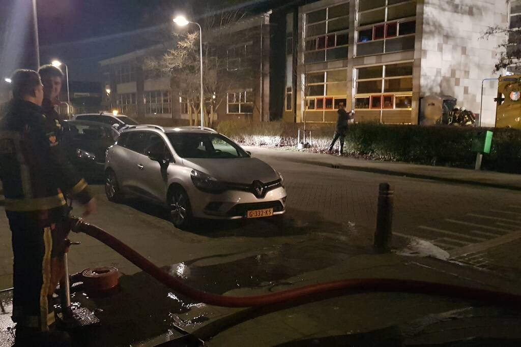 Kleding container vat vlam tegen schoolgebouw