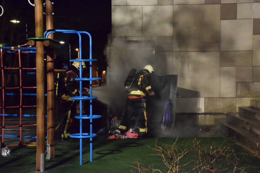 Kleding container vat vlam tegen schoolgebouw
