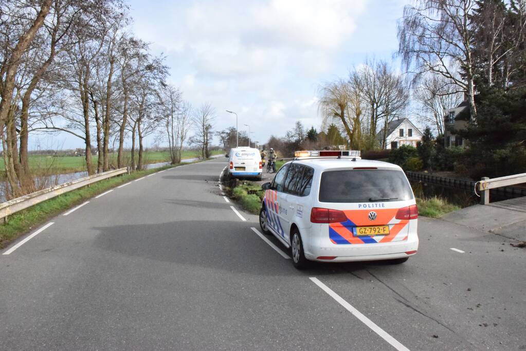 Bestelbus botst op lantaarnpaal komt tot stilstand op biggenruggen