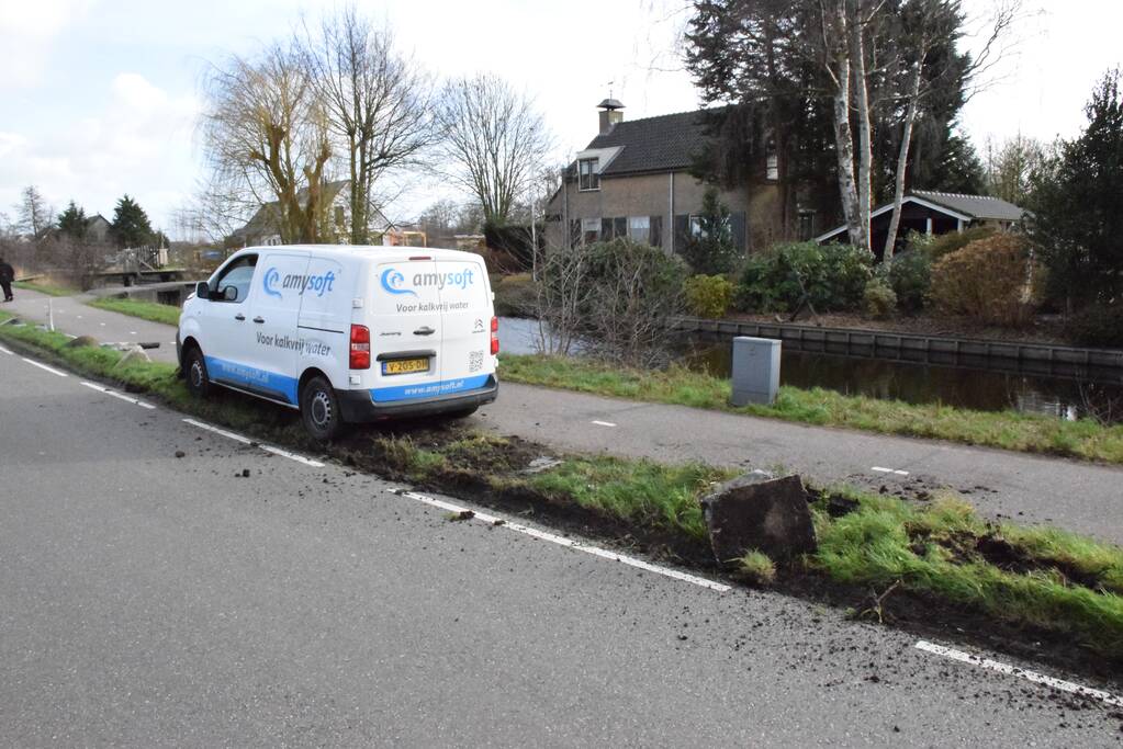 Bestelbus botst op lantaarnpaal komt tot stilstand op biggenruggen