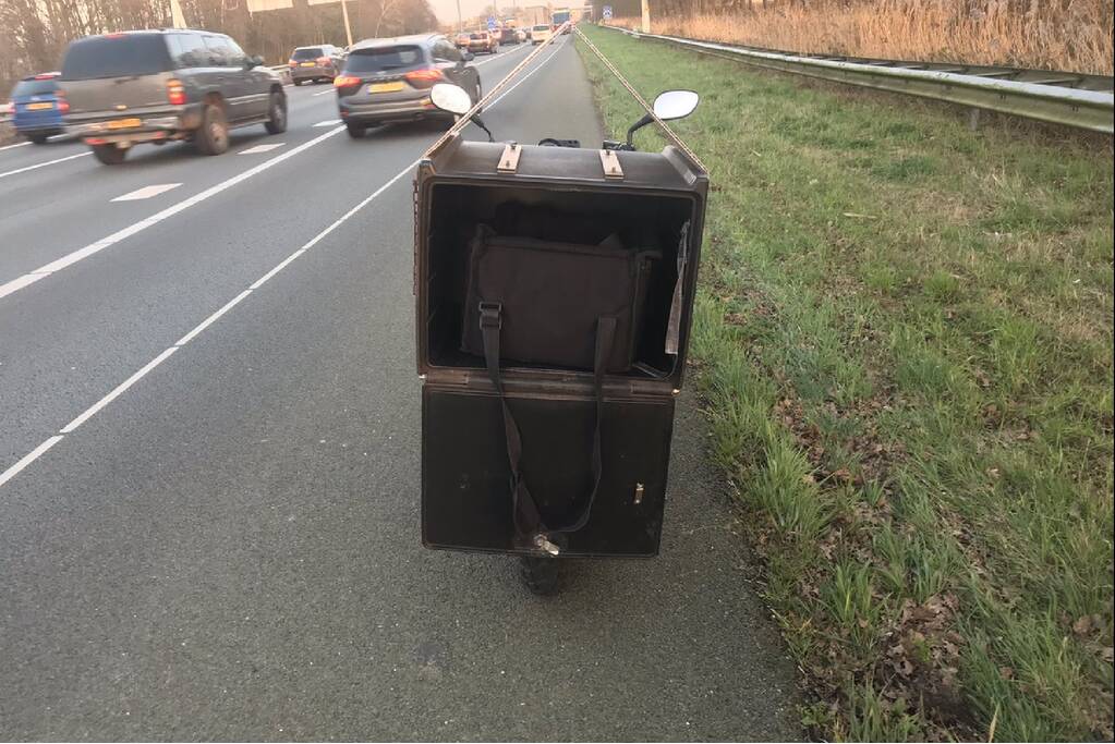 Pizzabezorger rijdt met scooter snelweg op