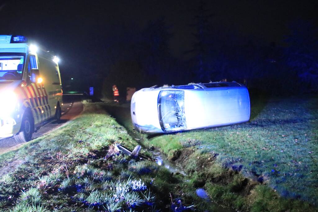 Bestelbus vliegt uit de bocht en belandt op zijkant, twee aanhoudingen