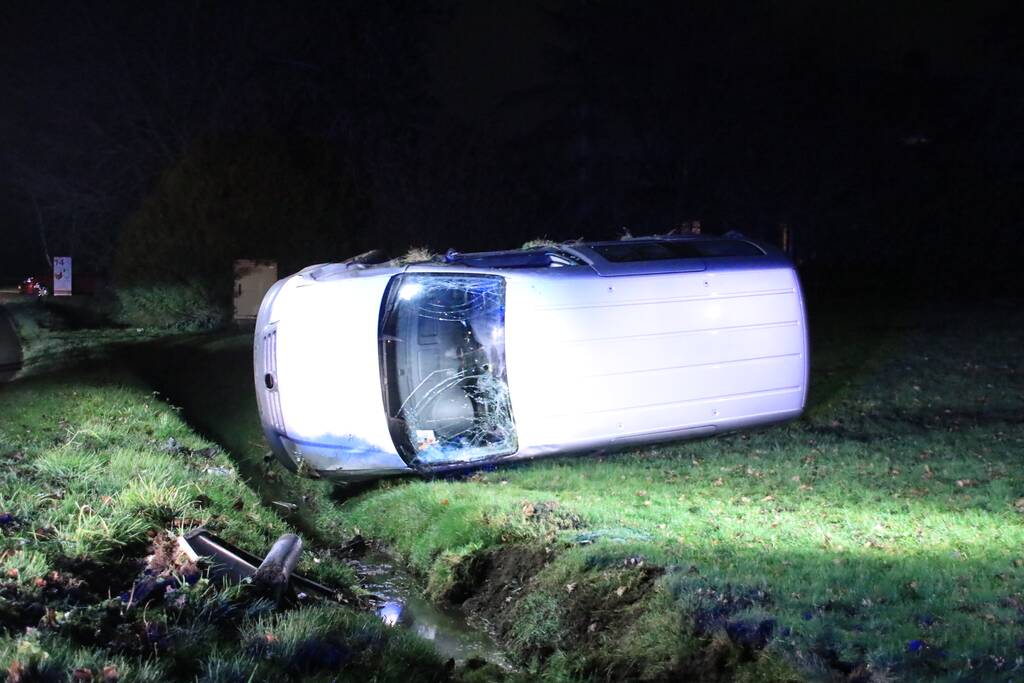 Bestelbus vliegt uit de bocht en belandt op zijkant, twee aanhoudingen