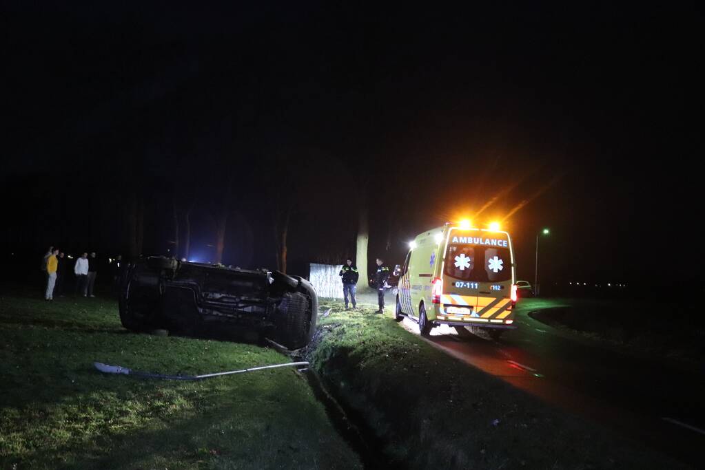 Bestelbus vliegt uit de bocht en belandt op zijkant, twee aanhoudingen