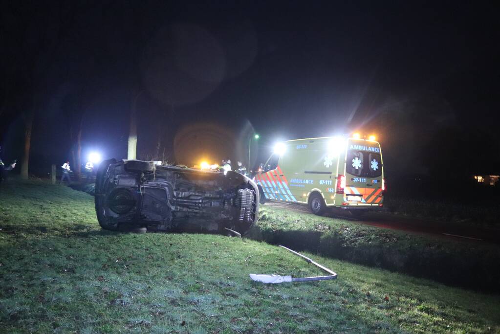Bestelbus vliegt uit de bocht en belandt op zijkant, twee aanhoudingen