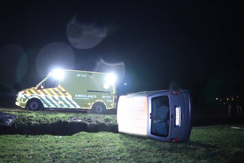 Bestelbus vliegt uit de bocht en belandt op zijkant, twee aanhoudingen