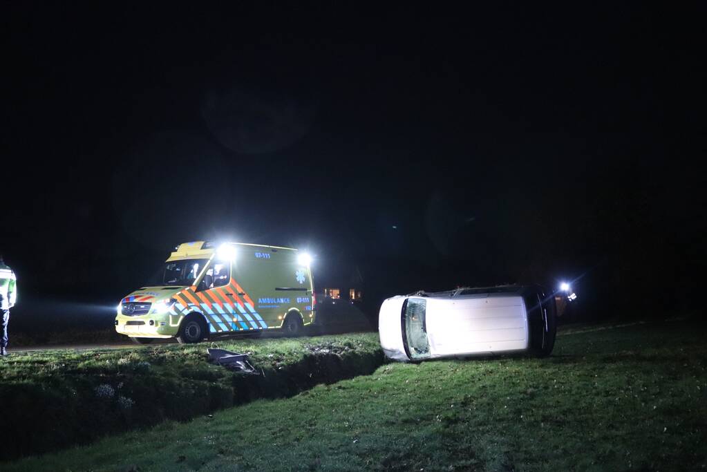 Bestelbus vliegt uit de bocht en belandt op zijkant, twee aanhoudingen