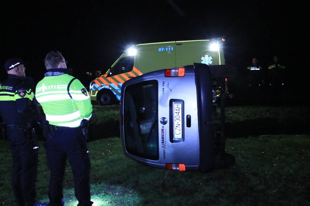 Bestelbus vliegt uit de bocht en belandt op zijkant, twee aanhoudingen